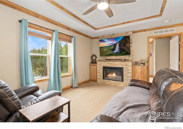 carpeted living room with ceiling fan, a fireplace, and a tray ceiling