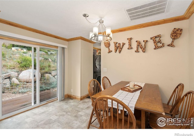 tiled dining space featuring stacked washer / dryer, an inviting chandelier, and crown molding