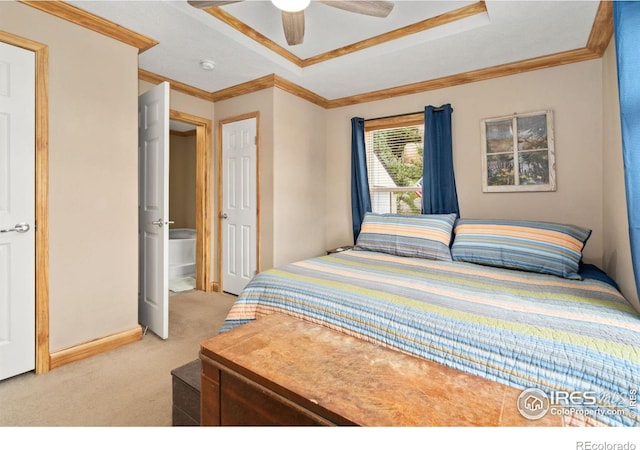 bedroom with a tray ceiling, crown molding, light carpet, and ceiling fan