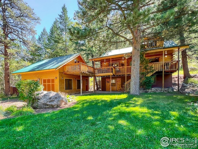 rear view of property featuring a deck and a lawn