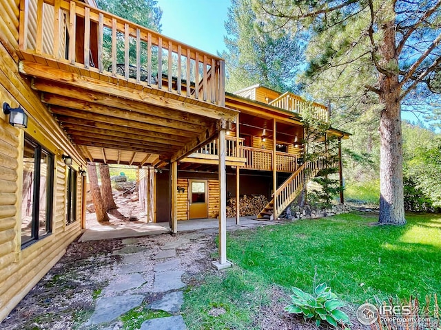 exterior space with a deck, a patio, and a lawn