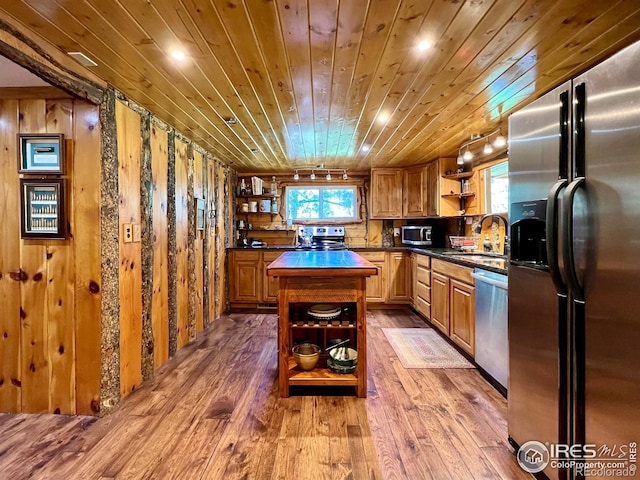 kitchen with wood-type flooring, appliances with stainless steel finishes, a kitchen island, and wooden ceiling