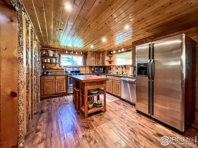 kitchen with a kitchen island, light hardwood / wood-style floors, appliances with stainless steel finishes, wooden ceiling, and sink