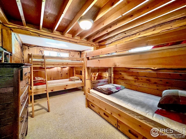 carpeted bedroom featuring wooden walls