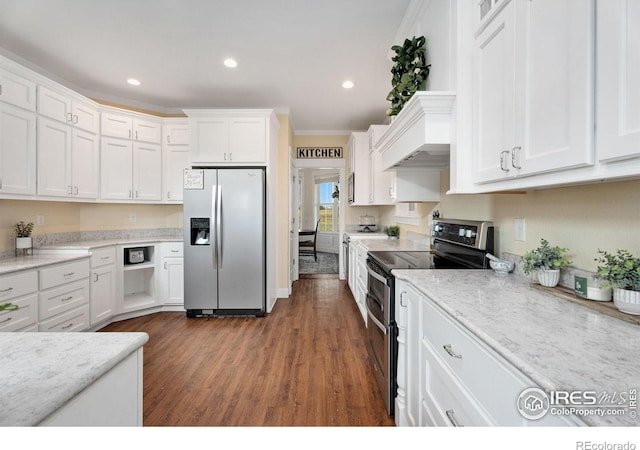 kitchen featuring appliances with stainless steel finishes, crown molding, light stone countertops, white cabinetry, and dark hardwood / wood-style flooring