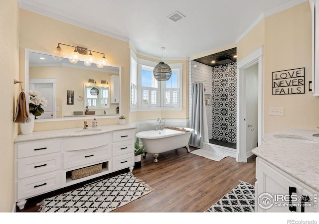 bathroom featuring vanity, crown molding, hardwood / wood-style flooring, and a bath