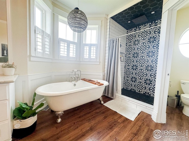 bathroom with toilet, a healthy amount of sunlight, crown molding, and hardwood / wood-style floors