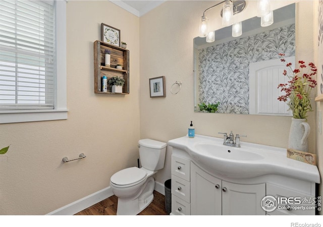 bathroom featuring vanity, crown molding, hardwood / wood-style flooring, and toilet