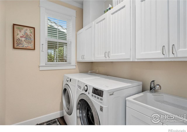 laundry area with washing machine and clothes dryer, sink, and cabinets