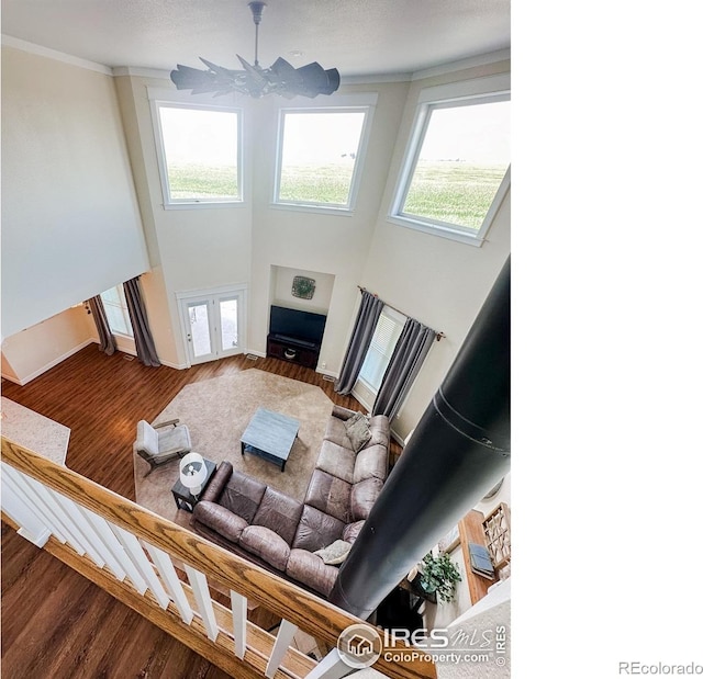 living room featuring a notable chandelier, wood-type flooring, and a towering ceiling