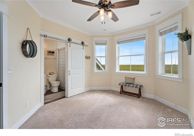 unfurnished bedroom with light colored carpet, connected bathroom, crown molding, and ceiling fan