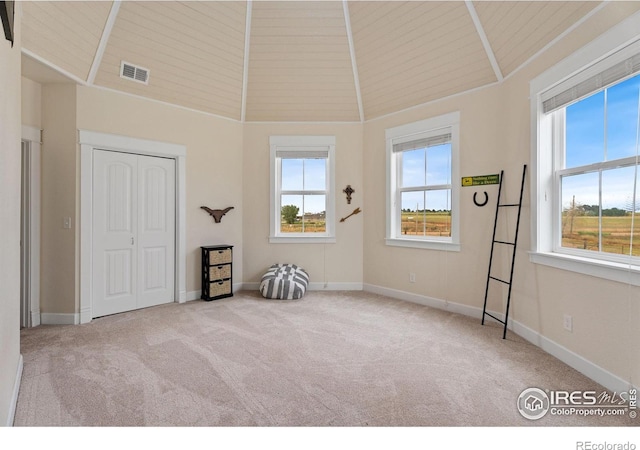 interior space with wooden ceiling, light colored carpet, a closet, and high vaulted ceiling