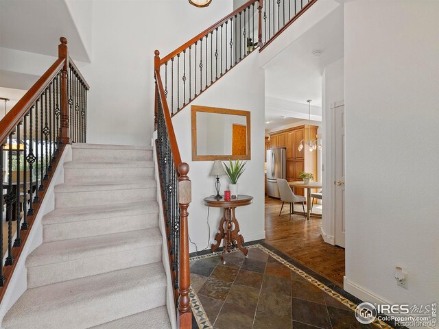 staircase featuring hardwood / wood-style flooring and a towering ceiling