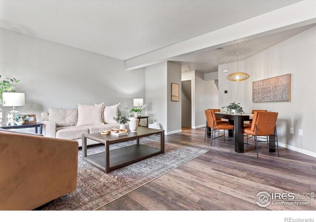 living room with beamed ceiling and wood-type flooring