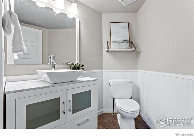 bathroom with hardwood / wood-style flooring, vanity, and toilet