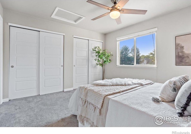 carpeted bedroom with ceiling fan and multiple closets