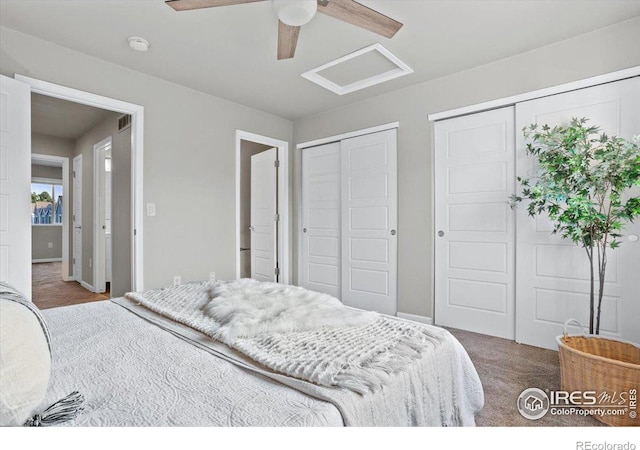 carpeted bedroom with ceiling fan and multiple closets