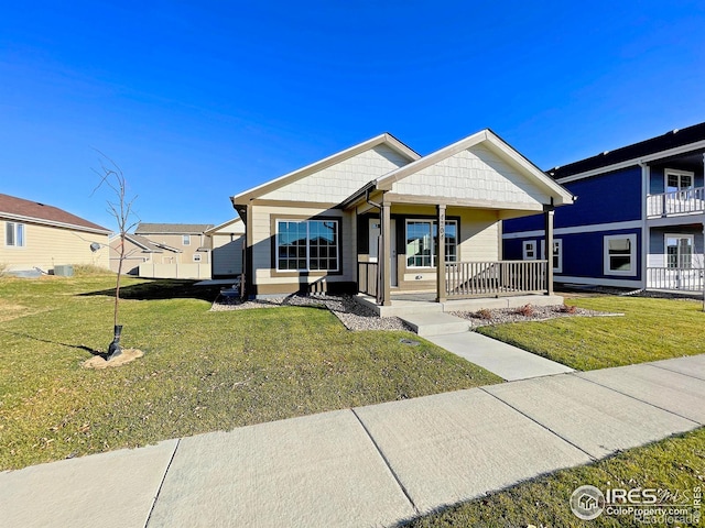 view of front of house with covered porch, central AC, and a front yard