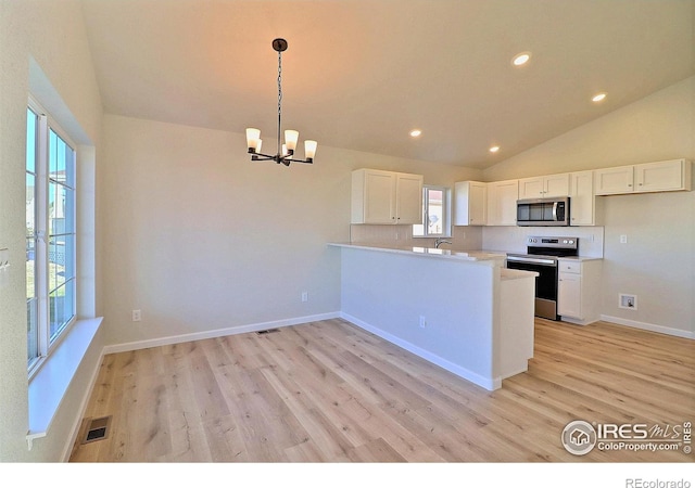 kitchen with white cabinets, appliances with stainless steel finishes, decorative light fixtures, and light hardwood / wood-style flooring