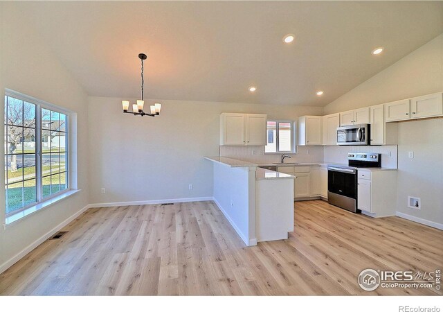 kitchen with white cabinets, a wealth of natural light, and appliances with stainless steel finishes