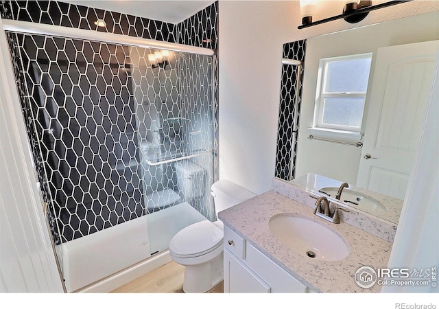 bathroom featuring a shower with shower door, toilet, wood-type flooring, and vanity