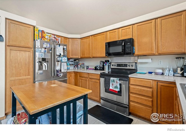 kitchen with decorative backsplash, stainless steel appliances, and light tile patterned floors