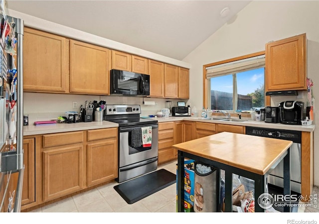 kitchen with sink, light tile patterned floors, vaulted ceiling, and stainless steel appliances