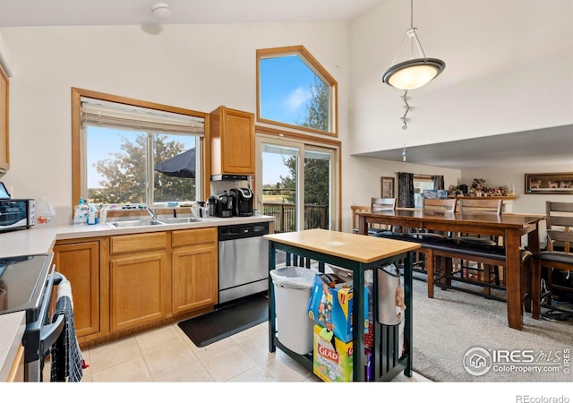 kitchen with range, pendant lighting, sink, dishwasher, and light tile patterned floors