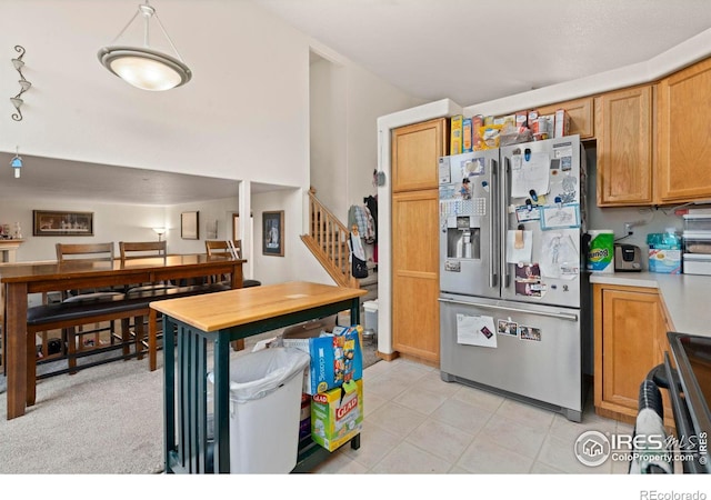 kitchen featuring stainless steel fridge, electric range oven, and light carpet