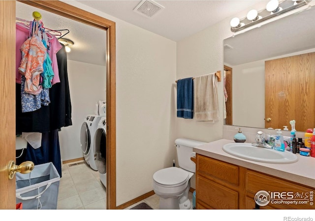 bathroom with vanity, tile patterned flooring, independent washer and dryer, and toilet