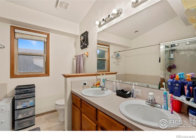 bathroom with lofted ceiling, tile patterned floors, toilet, and dual bowl vanity