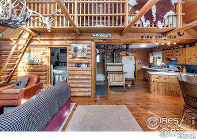 kitchen featuring log walls and hardwood / wood-style floors