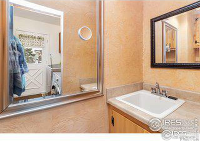 bathroom with washer / dryer and vanity