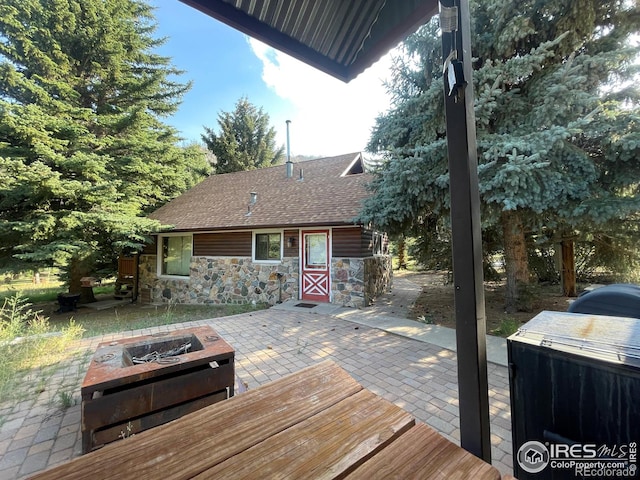 wooden terrace featuring a patio and a fire pit