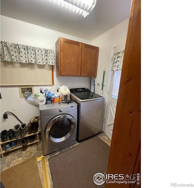 laundry room with tile patterned flooring, washing machine and clothes dryer, and cabinets