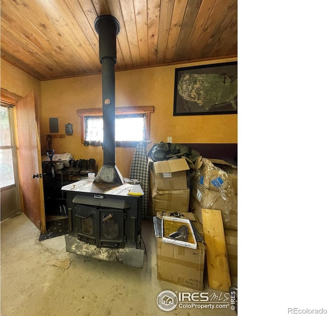 living room featuring a wood stove and wooden ceiling