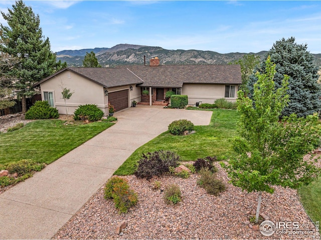 ranch-style home featuring a garage, a mountain view, and a front lawn