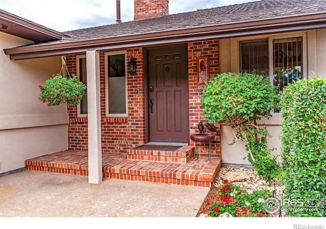 view of exterior entry with a patio area