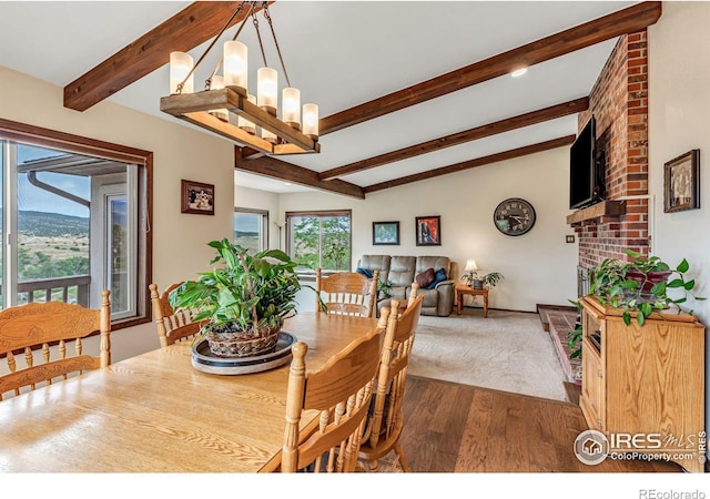 dining area featuring lofted ceiling with beams, brick wall, a chandelier, and hardwood / wood-style flooring