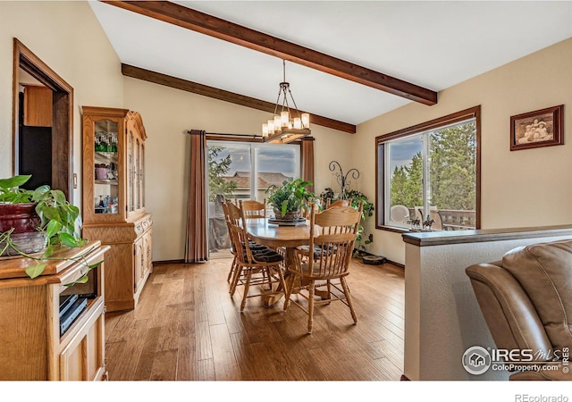 dining area featuring light hardwood / wood-style floors, vaulted ceiling with beams, and an inviting chandelier