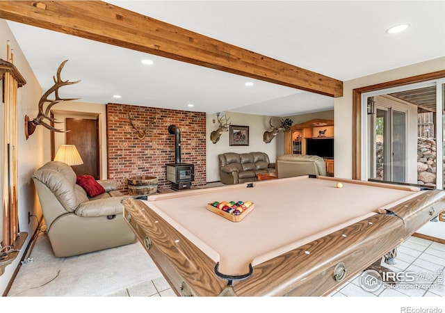 game room featuring light tile patterned flooring, pool table, beam ceiling, and a wood stove