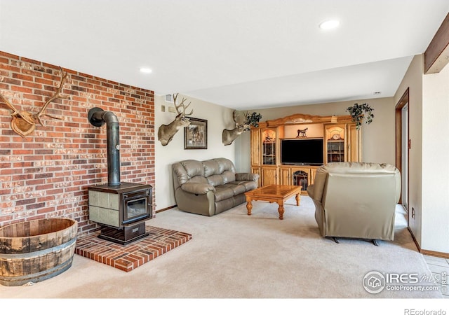 carpeted living room featuring a wood stove and brick wall