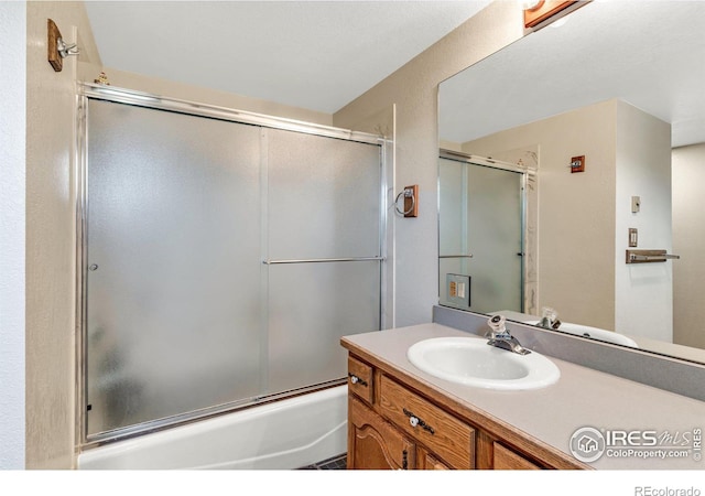 bathroom with vanity and enclosed tub / shower combo