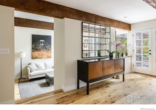 interior space featuring beamed ceiling and light wood-type flooring