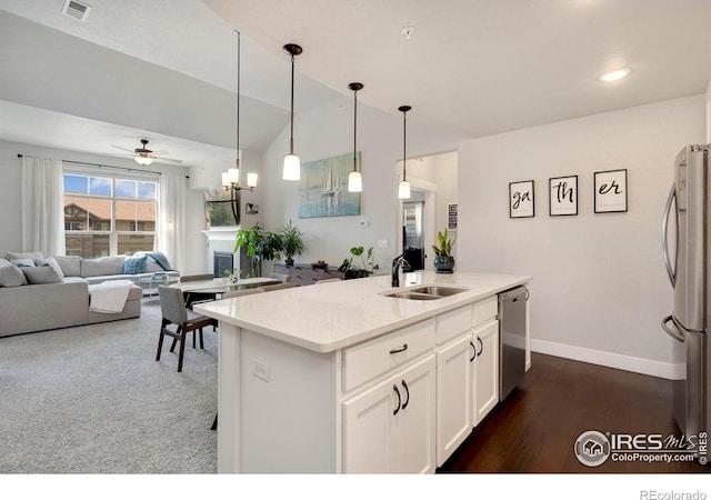 kitchen featuring appliances with stainless steel finishes, a kitchen island with sink, sink, white cabinets, and hanging light fixtures