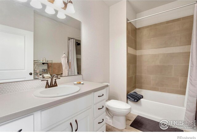 bathroom featuring toilet, vanity, and shower / bath combination with curtain