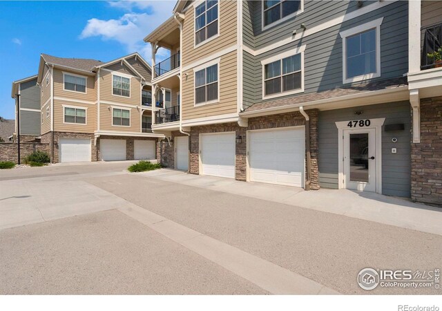 exterior space featuring stone siding and an attached garage