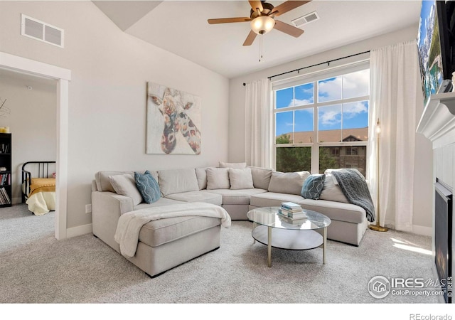 carpeted living area featuring visible vents, a fireplace, a ceiling fan, and baseboards