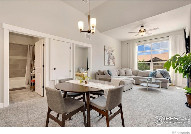 dining space with light carpet and ceiling fan with notable chandelier