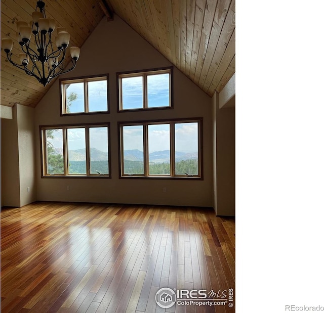 interior space with wood-type flooring, wood ceiling, high vaulted ceiling, and an inviting chandelier